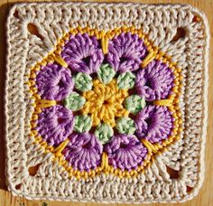 a crocheted square with flowers on it