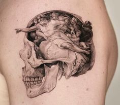 a man's shoulder with a skull and an angel on it, in black and white