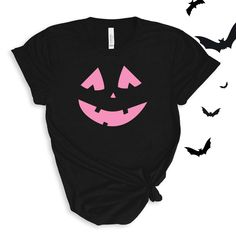 a black t - shirt with pink face and bats around it