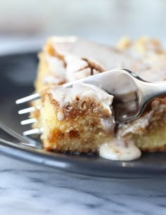 a piece of cake on a plate with a fork sticking out of it and drizzled with icing