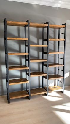 two shelving units with wooden shelves in an empty room