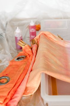 there are many different items in the box and on the table, including an orange scarf