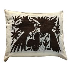 an embroidered pillow with two birds and flowers on the front, in black and white