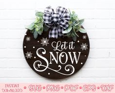 a sign that says let it snow on the side of a brick wall with greenery