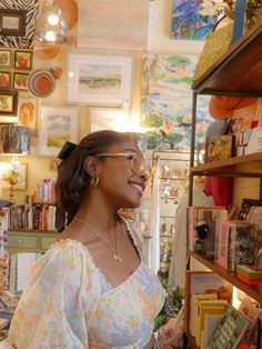 a woman standing in front of a shelf filled with books