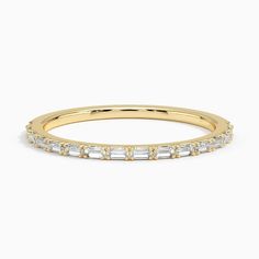 a yellow gold wedding band with baguettes on the sides and diamonds in the middle