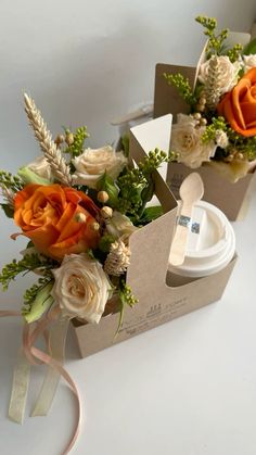 two boxes with flowers in them sitting on a table