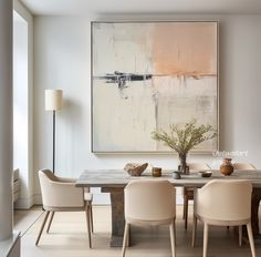 a dining room table with white chairs and a large painting on the wall behind it