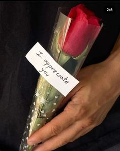 a woman holding a red rose with a note attached to it that says i appreciate you