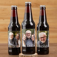 three personalized beer bottles sitting on top of a wooden table next to each other