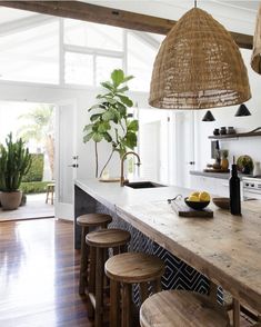 a kitchen island with stools next to it and a potted plant on the counter