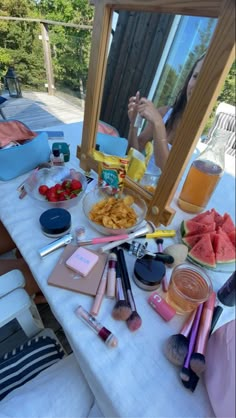 a table topped with lots of different types of makeup and other items on top of it