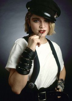 a woman dressed as a police officer with her finger in her mouth, posing for the camera