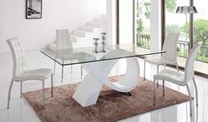 a glass table with white chairs around it