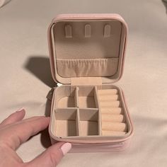 someone is holding an open pink case with compartments