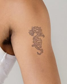 a woman with a dragon tattoo on her left arm and right arm behind her back