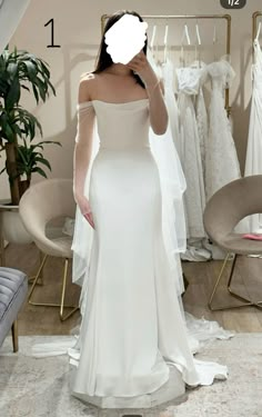 a woman standing in front of a wedding dress