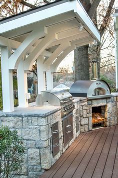 an outdoor bbq and grill area with wood decking