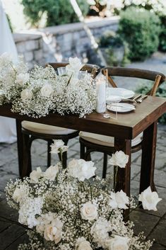 the table is set with white flowers and candles