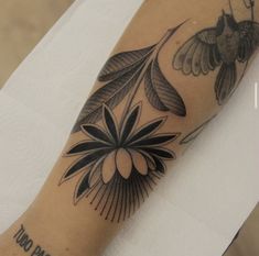 a close up of a person's arm with tattoos on it and a bird