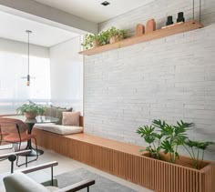 a living room filled with lots of furniture next to a white brick wall covered in potted plants