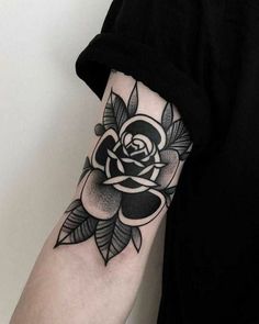 a black and white rose tattoo on the arm