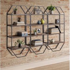 a book shelf with books on it against a brick wall