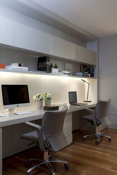 an office desk with two computer monitors on it