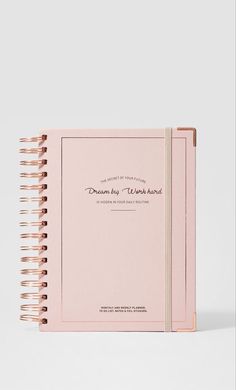 a pink notebook with the words dream big work hard written in gold foil on it