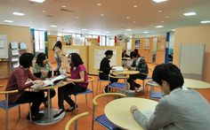 several people sitting at desks in a classroom