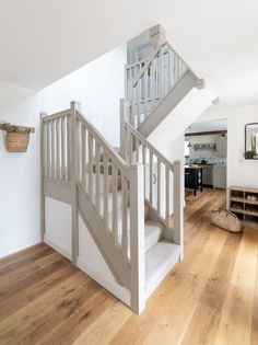 an open staircase in a house with hardwood floors and white walls, leading up to the second floor