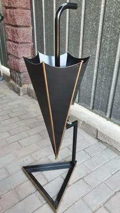 an upside down umbrella stand on the sidewalk