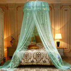 a bed with a canopy over it sitting in a room next to a dresser and lamp