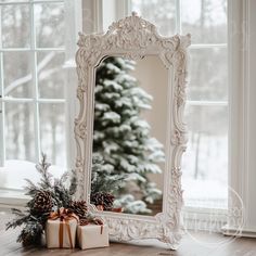 a white mirror sitting on top of a wooden floor next to a christmas tree and presents