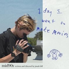 a man holding a camera in front of a white board with writing on it that says, today i want to make movies