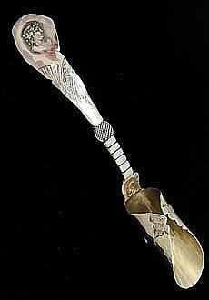 a silver spoon with an ornate design on it