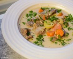 a white bowl filled with soup and vegetables