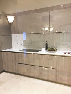 an empty kitchen with marble counter tops and white tile flooring on the side wall