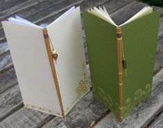 an open book sitting on top of a wooden table next to another book that is closed