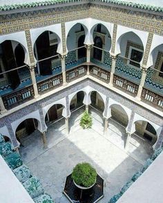 an aerial view of a courtyard with blue and white tiles on the walls, windows and balconies