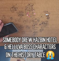 someone is drawing on the wall with their cell phone and writing on it that says, somebody drew hazbin hotel & hella boss characters on the history table