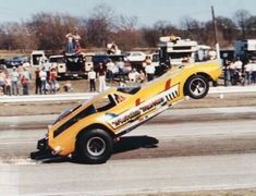 a yellow race car is upside down on its side