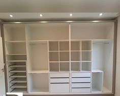 an empty walk - in closet with white shelves, drawers and shelving units on the wall