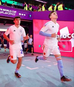 two men are playing soccer in front of an audience at the olympics games, with spectators watching