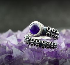 Evoke the mysteries of the deep with this stunning sterling silver octopus tentacle ring featuring a fascinating natural star sapphire. Handcrafted with meticulous attention to detail, this unique piece of marine jewelry is sure to make a splash. The intricate octopus tentacle design wraps around your finger, creating a bold piece that is both stylish and edgy. Star sapphire sparkles and shines with iridescent hues, reminiscent of the changing colors of the ocean. This ring is the perfect access Octopus Accessories, Tentacle Ring, Marine Jewelry, Tentacles Ring, Octopus Ring, Octopus Tentacles, Sea Jewelry, Star Sapphire, Silver Prices