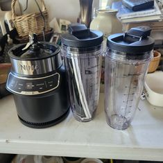 two blenders sitting next to each other on a counter