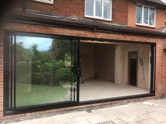 an empty room with sliding glass doors in front of a brick building that is being renovated