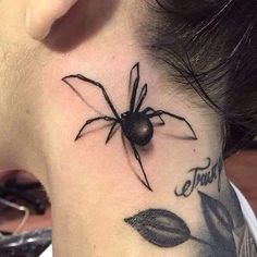 a woman's neck with a spider tattoo on it