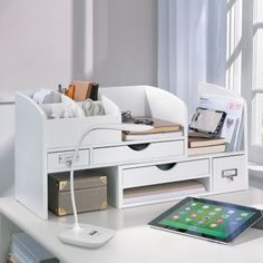 a white desk with a tablet and drawers