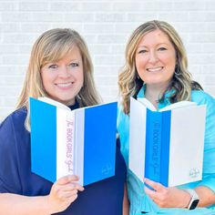 two women are holding blue and white books